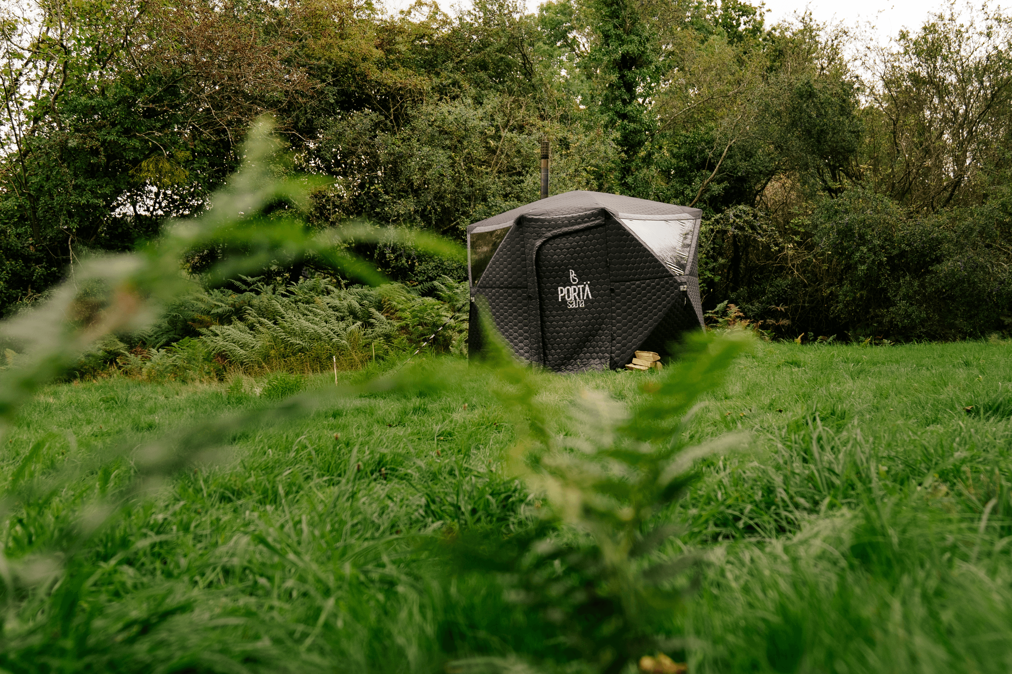 Portable sauna tent set up in a green meadow